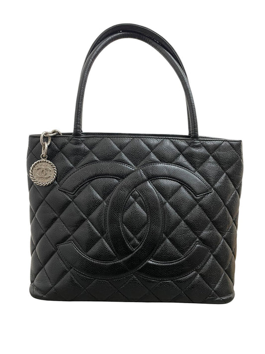 Borsa Chanel Medallion Tote in pelle Caviar nera con maxi logo CC frontale e hardware argento su sfondo bianco