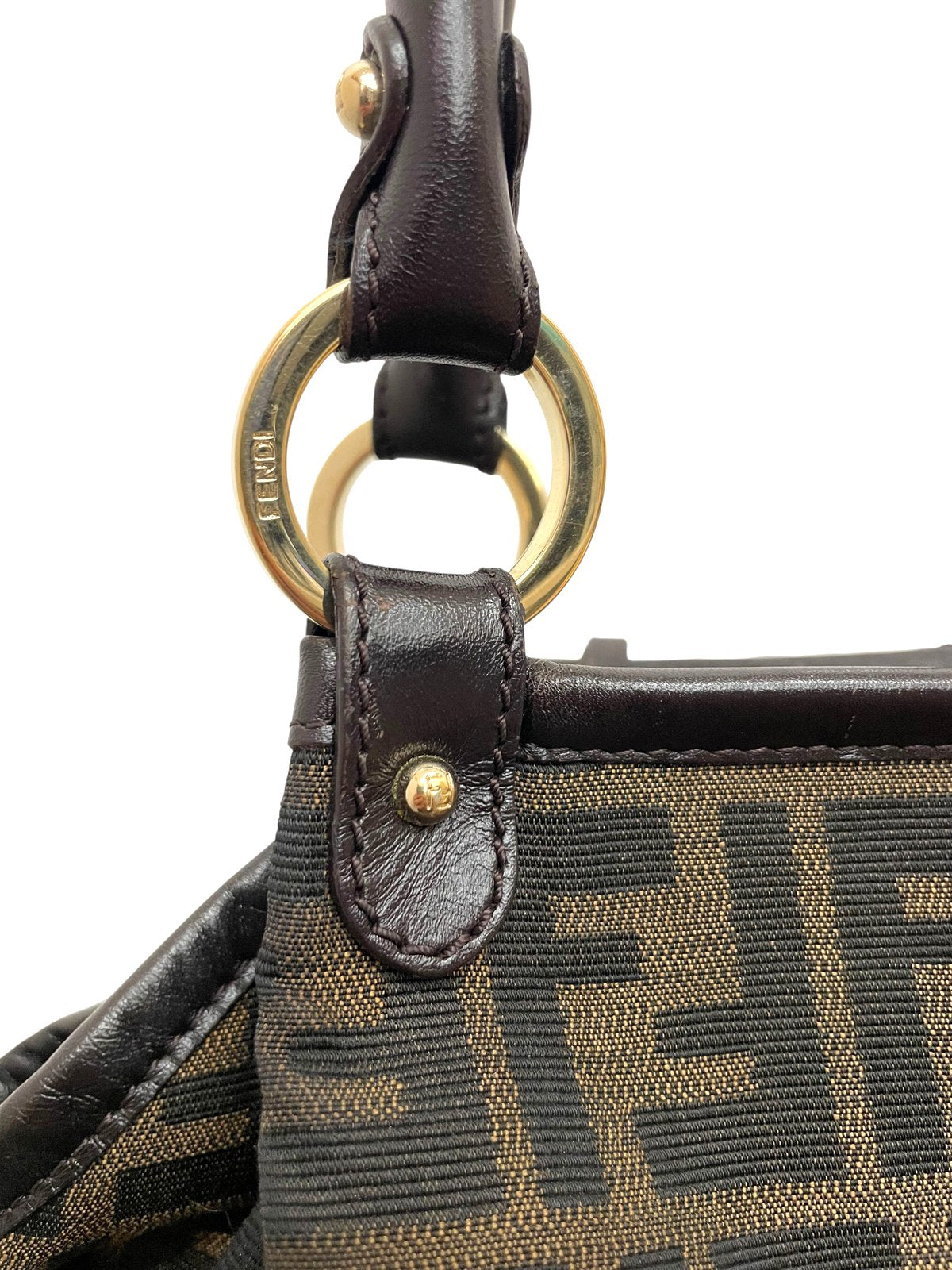 Dettaglio ravvicinato dell'anello metallico dorato e dell'attacco del manico in pelle della borsa Fendi