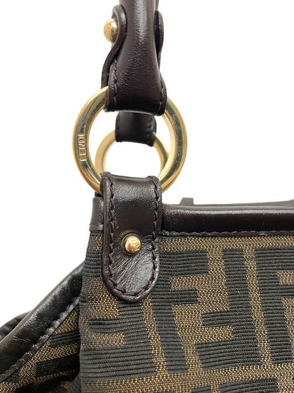 Dettaglio ravvicinato dell'anello metallico dorato e dell'attacco del manico in pelle della borsa Fendi