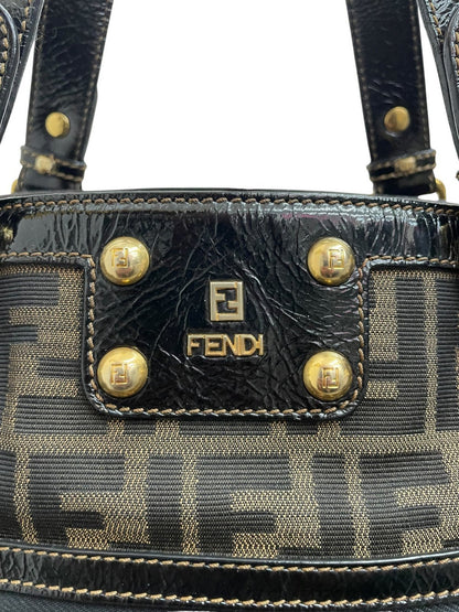Dettaglio logo Fendi in metallo dorato lucido su borsa Zucca