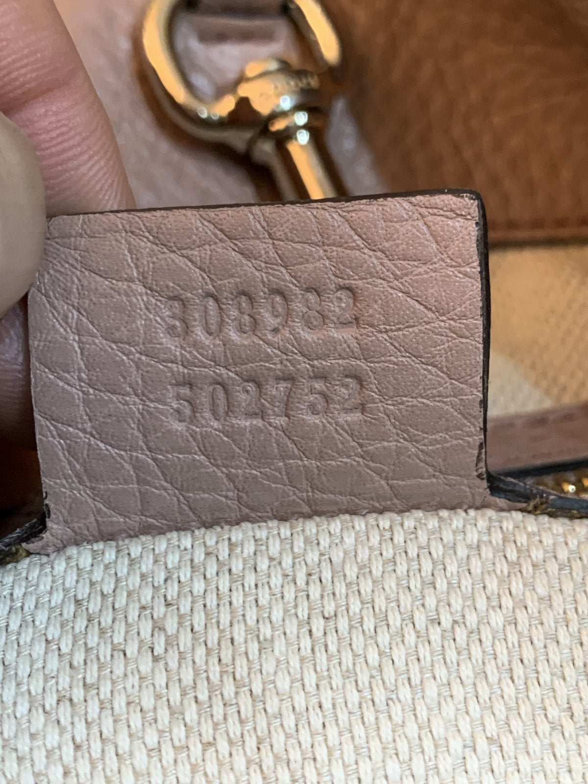 Primo piano del codice seriale Gucci 308982 502752 impresso sul retro dell'etichetta in pelle interna per verifica autenticità