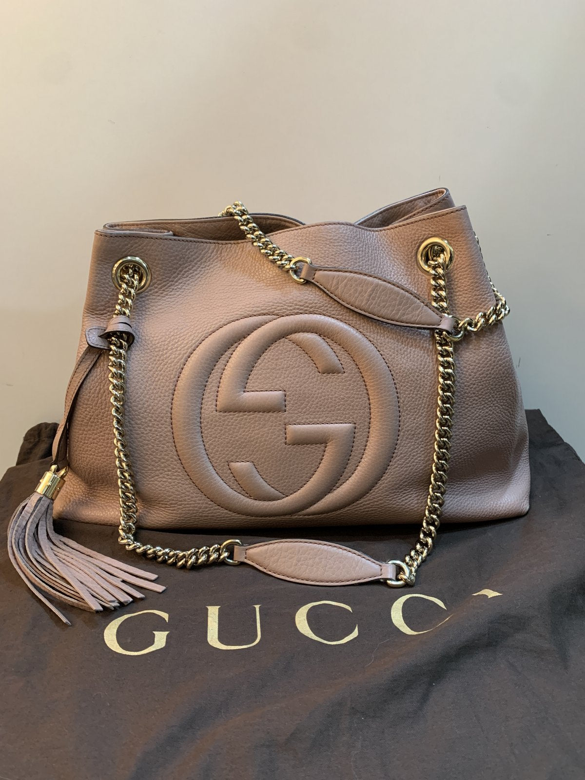 Borsa Gucci Soho Chain Medium in pelle rosa nude adagiata sopra la sua dust bag originale marrone firmata Gucci