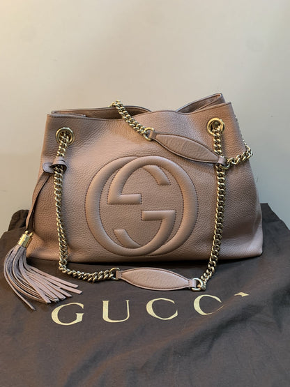 Borsa Gucci Soho Chain Medium in pelle rosa nude adagiata sopra la sua dust bag originale marrone firmata Gucci