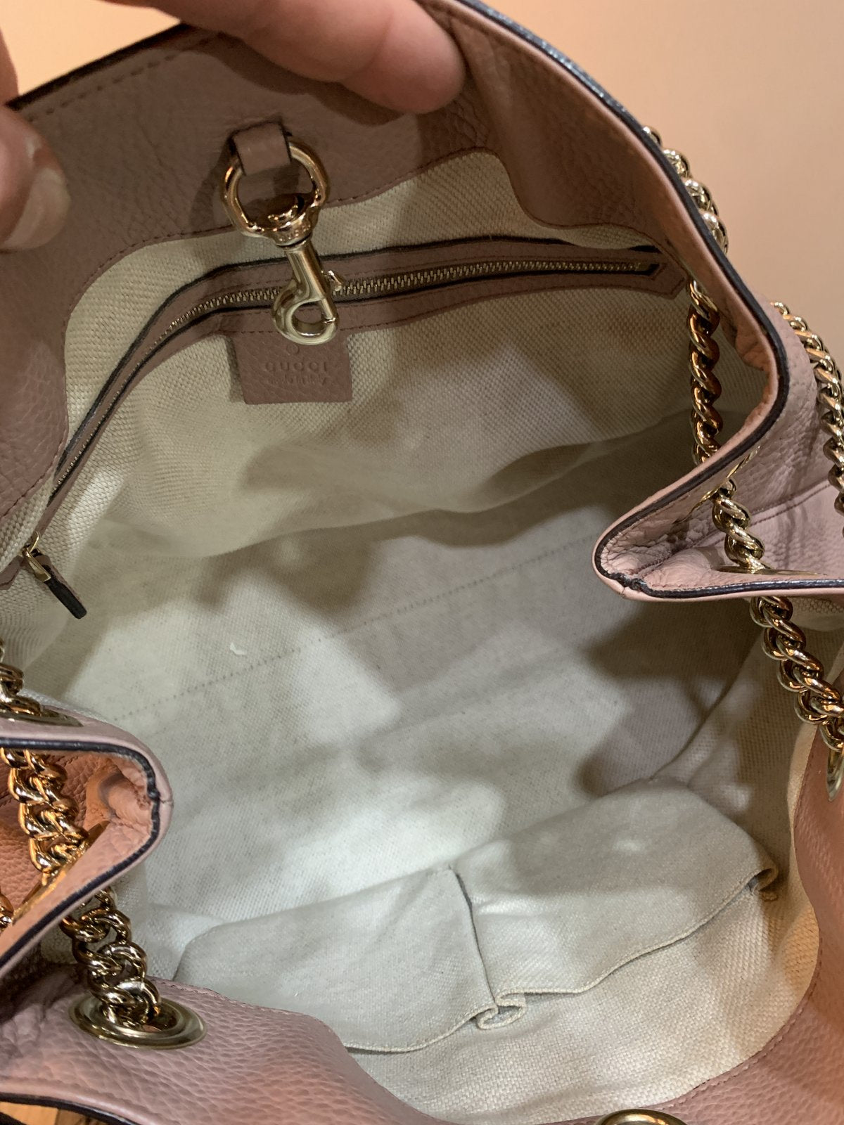 Interno capiente della borsa Gucci Soho Chain foderato in tessuto chiaro con tasche portaoggetti.