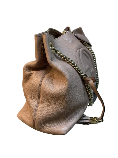 Vista laterale di profilo della borsa Gucci Soho Chain in pelle morbida rosa cipria con catena dorata.