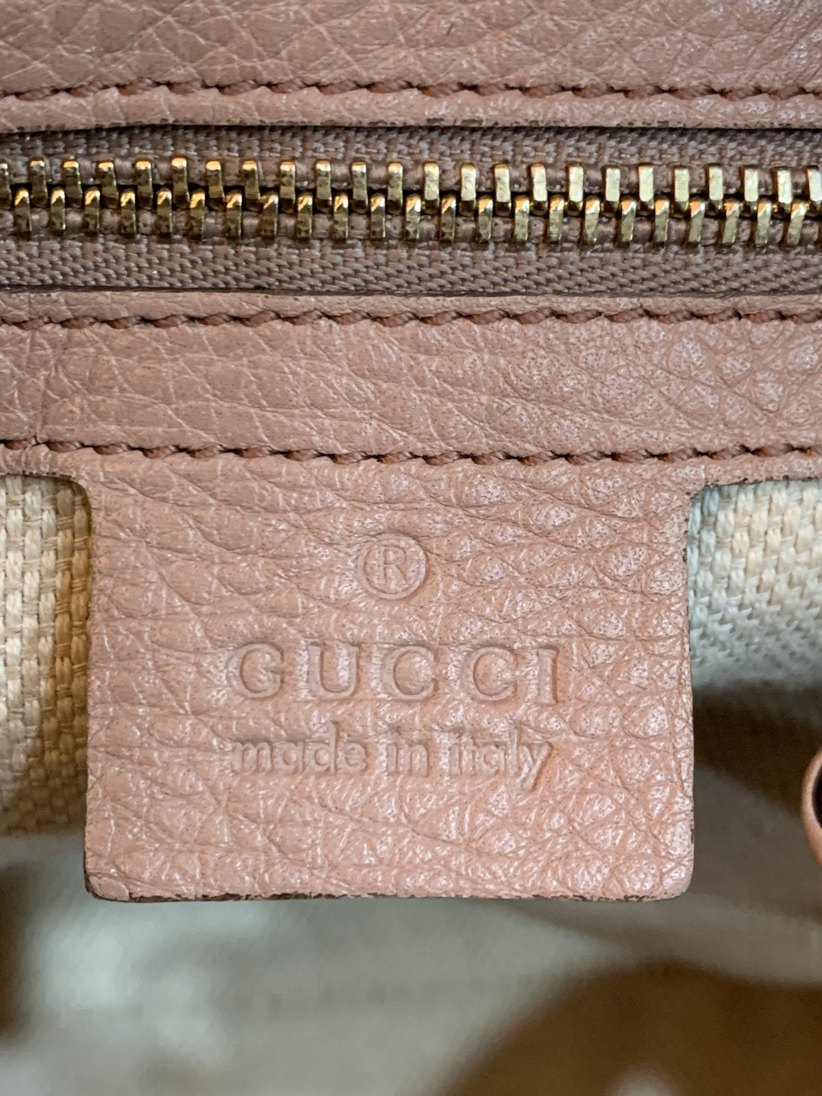Dettaglio della tasca interna con cerniera lampo e rifiniture in pelle rosa della borsa Gucci Soho Chain.