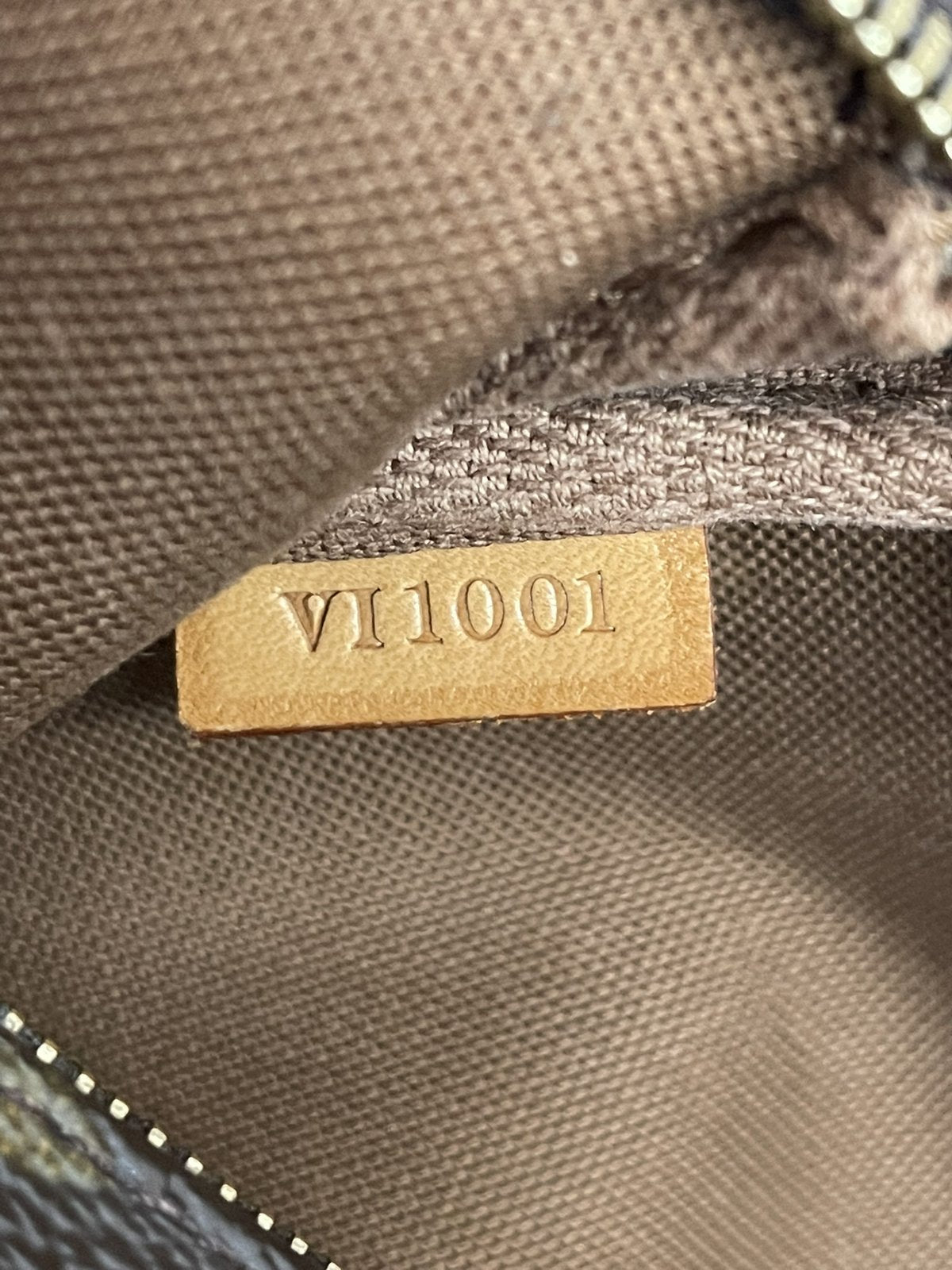 Dettaglio del codice seriale di autenticità VI0015 impresso sulla linguetta interna in pelle della borsa Louis Vuitton.