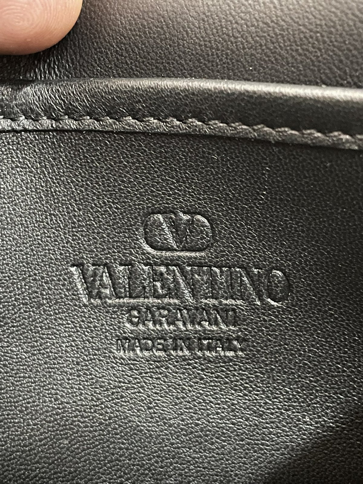Dettaglio del logo Valentino Garavani Made in Italy stampato a caldo sulla pelle della tasca interna della borsa Rockstud Spike