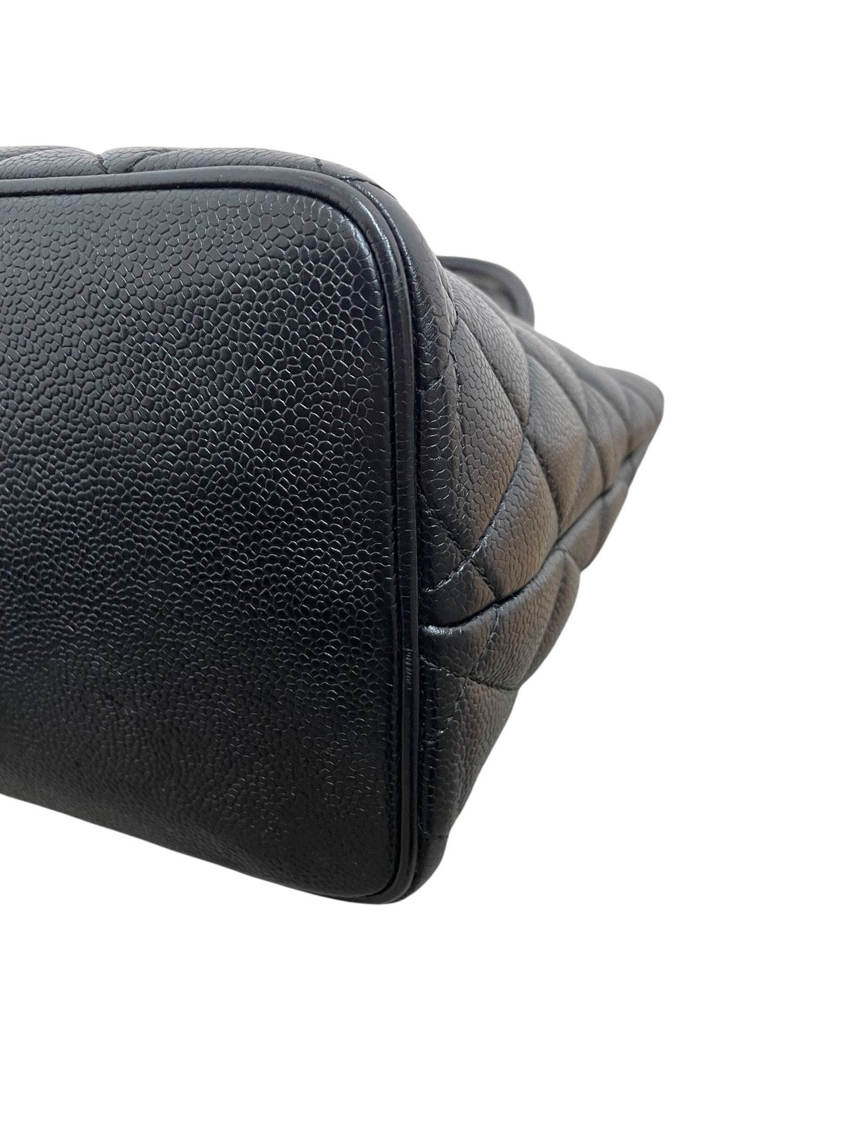 Primo piano dell'angolo inferiore destro della borsa in pelle Caviar nera che mostra lo stato di conservazione