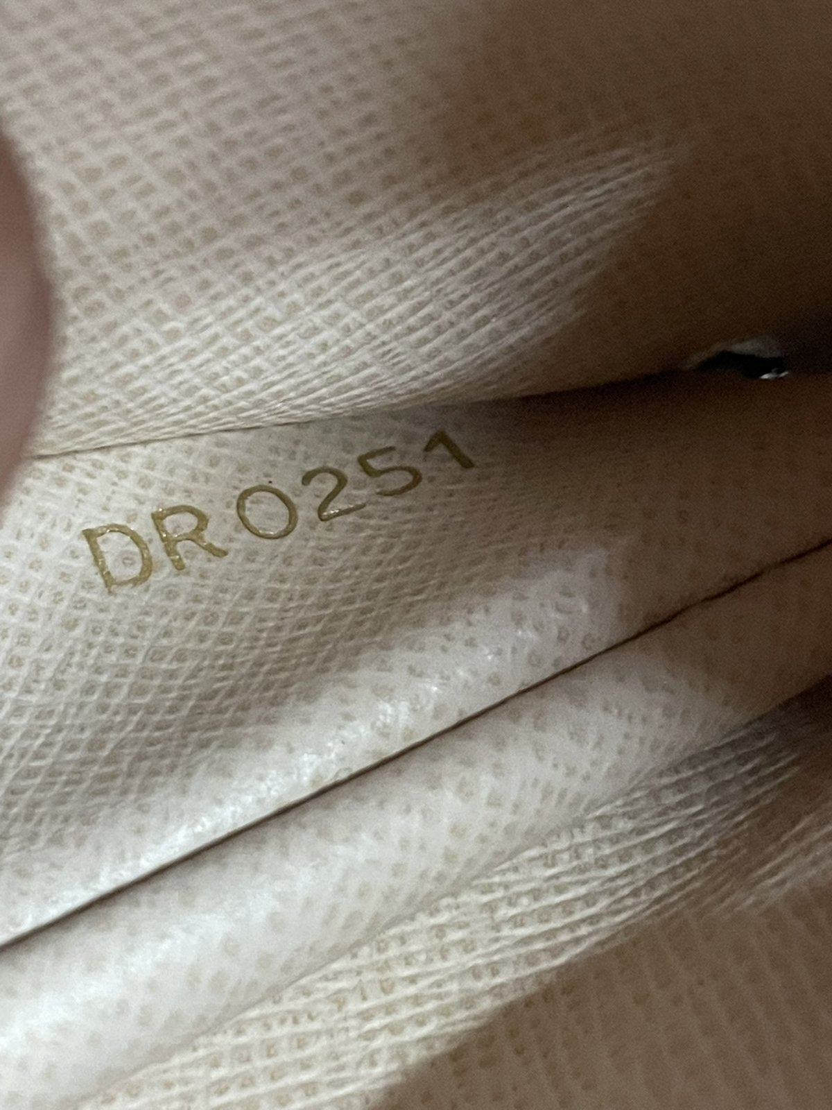 Dettaglio del numero seriale impresso all'interno della fodera del portamonete Louis Vuitton