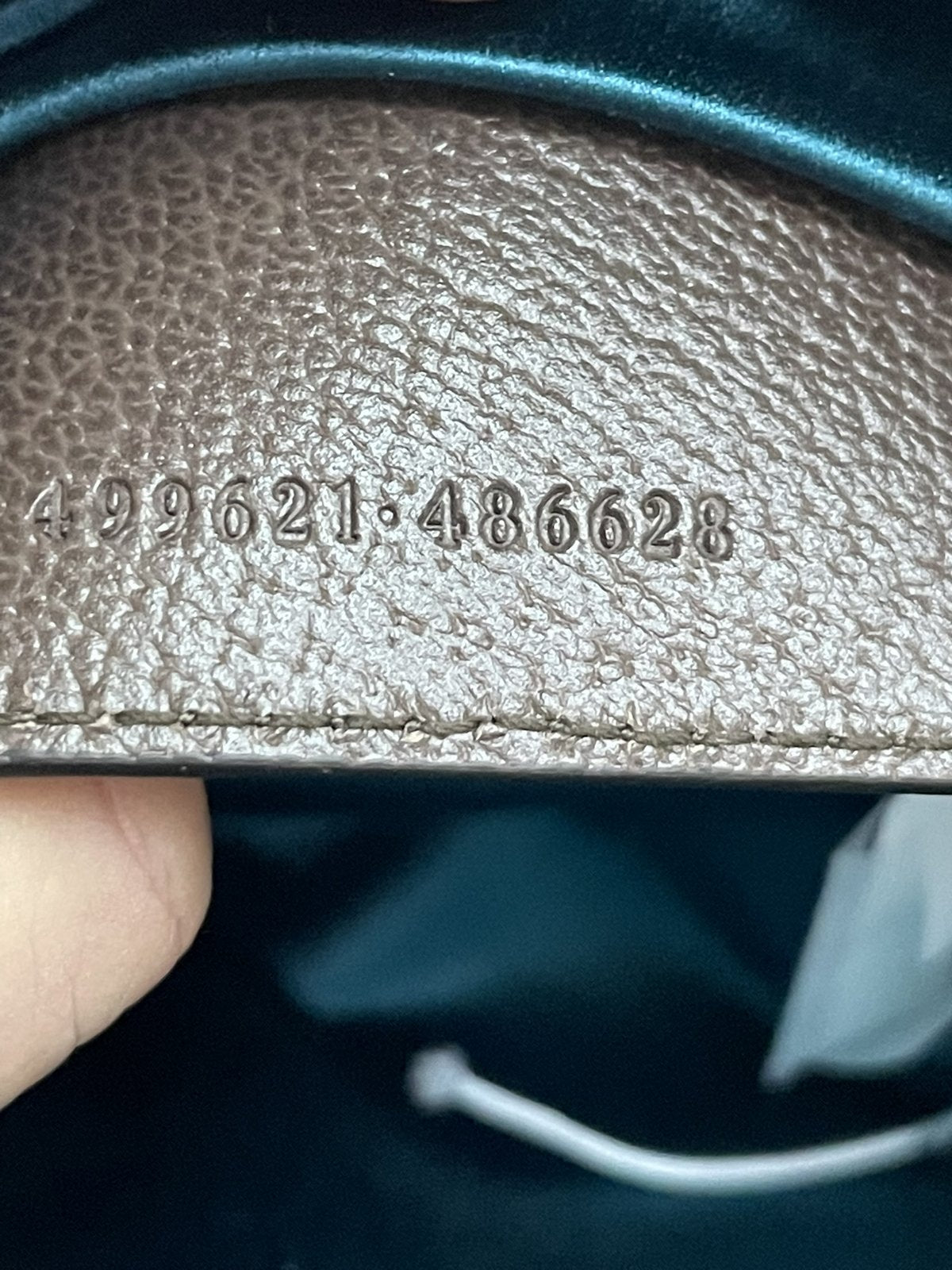 Numero di serie Gucci 499621 impresso a caldo sul retro della linguetta in pelle all'interno del taschino