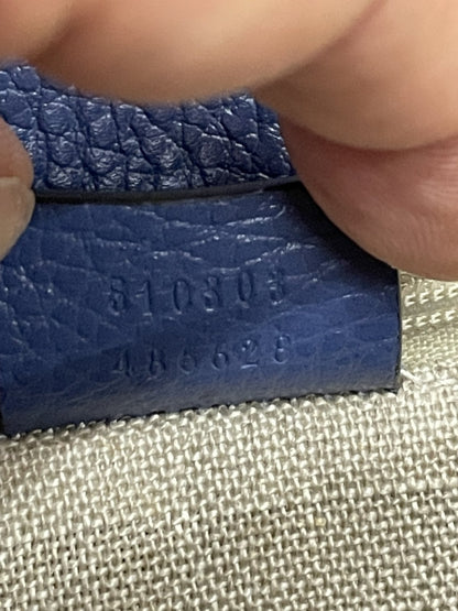 Primo piano del codice seriale Gucci punzonato sul retro della targhetta