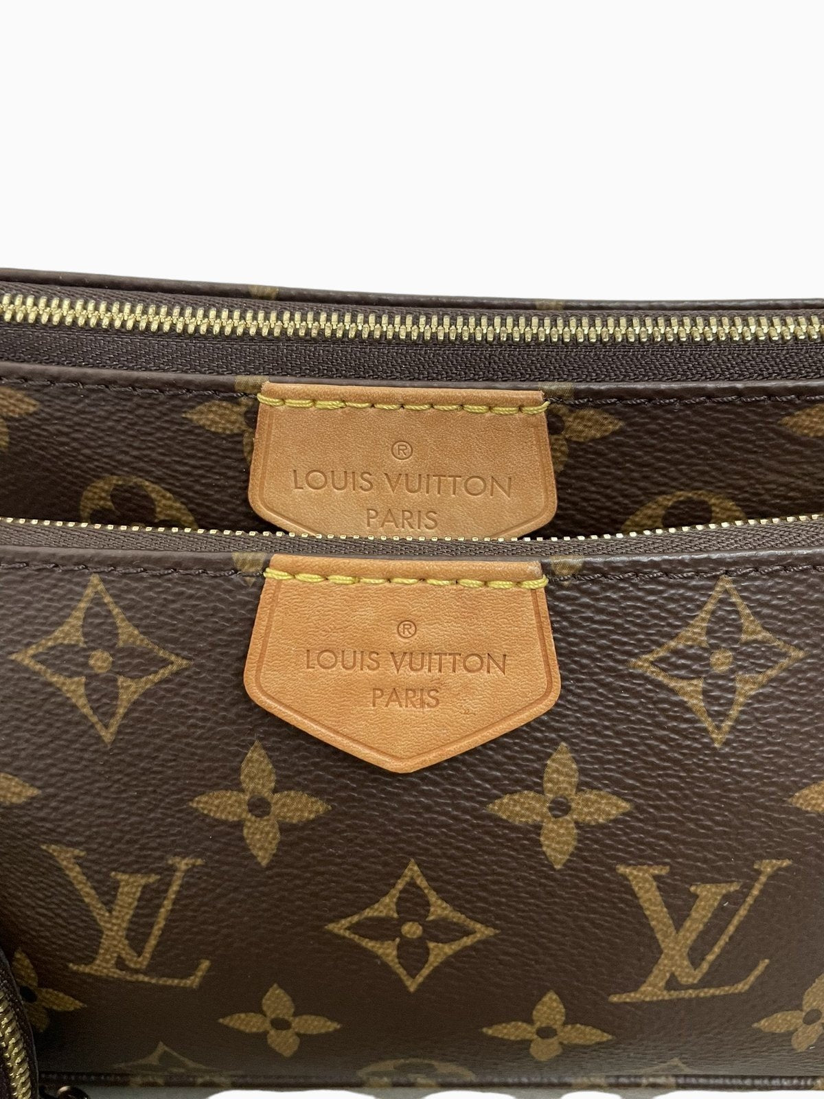 Dettaglio della patch in pelle con marchio impresso Louis Vuitton Paris sulla borsa Multi Pochette