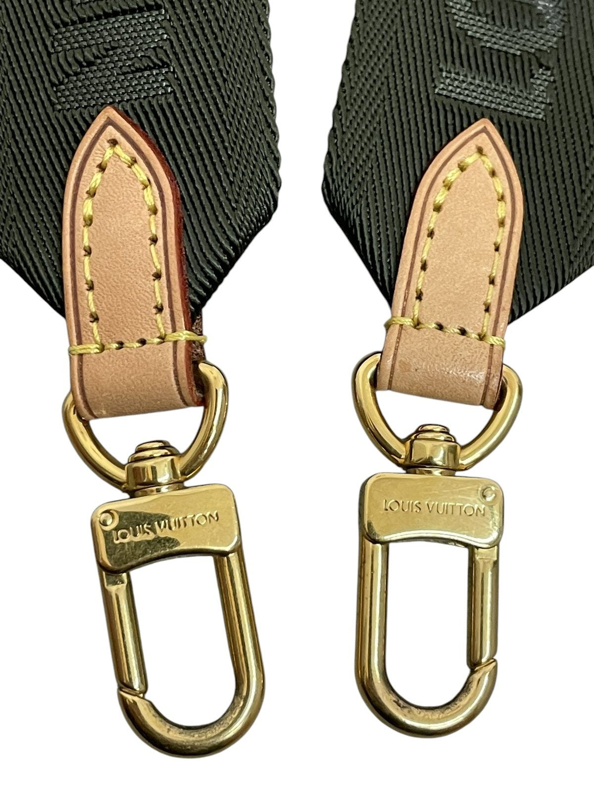 Primi piani dei moschettoni dorati lucidi della tracolla in tessuto Louis Vuitton