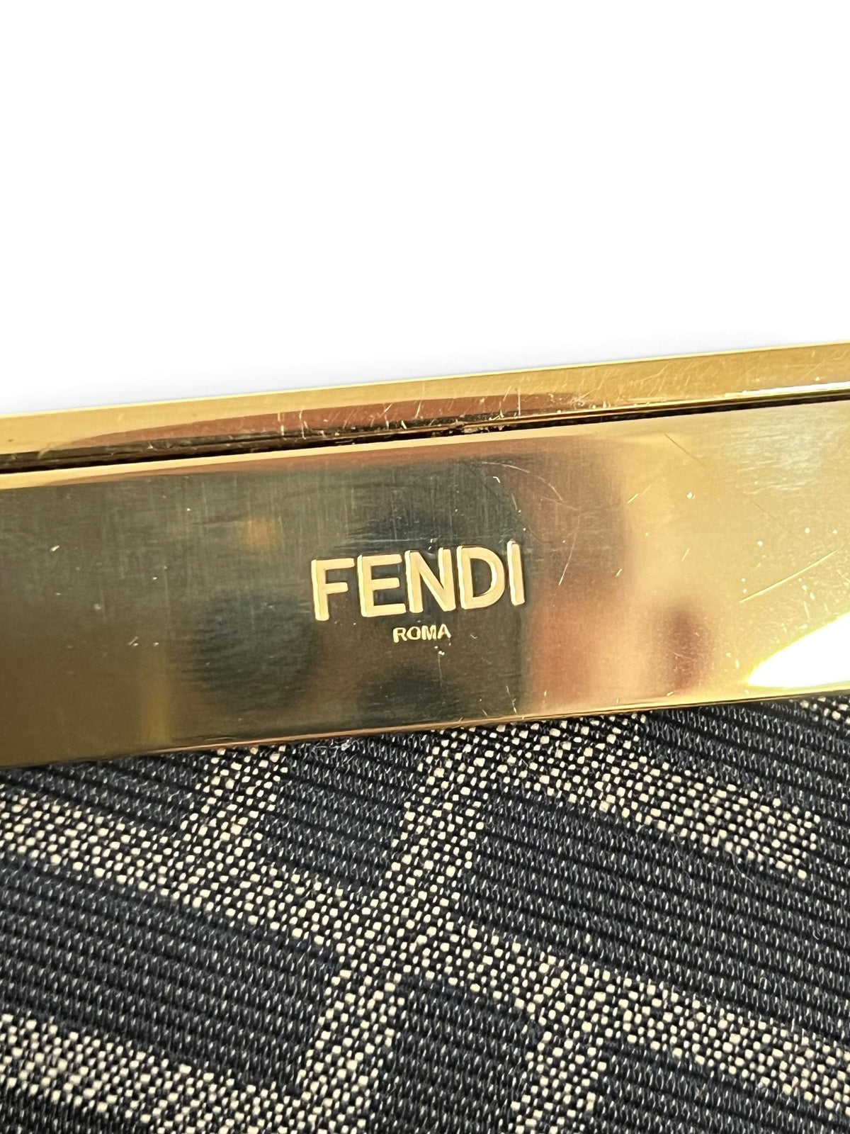 Dettaglio chiusura rigida dorata con logo Fendi Roma inciso