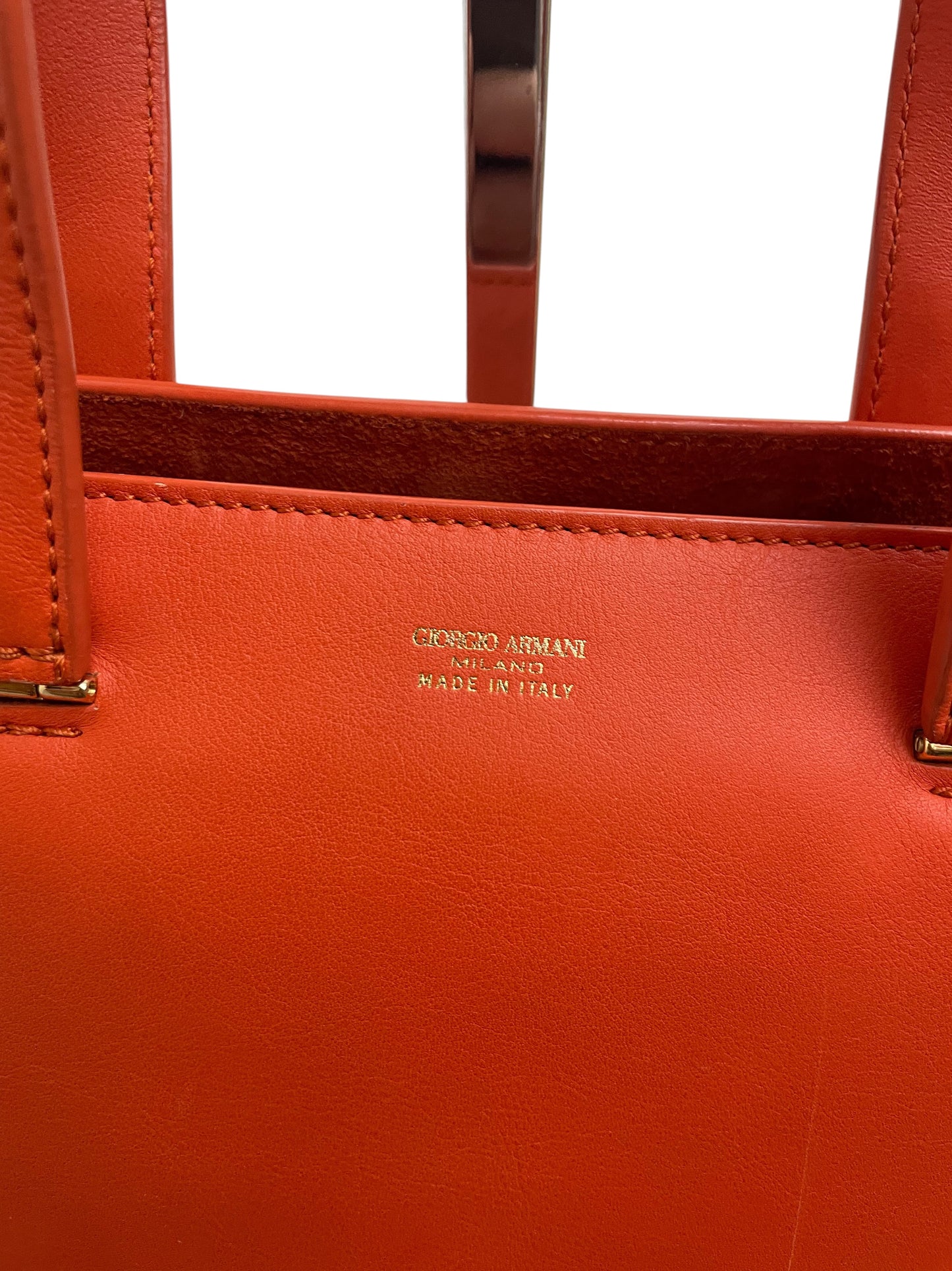 Logo Giorgio Armani Milano impresso sulla pelle arancio