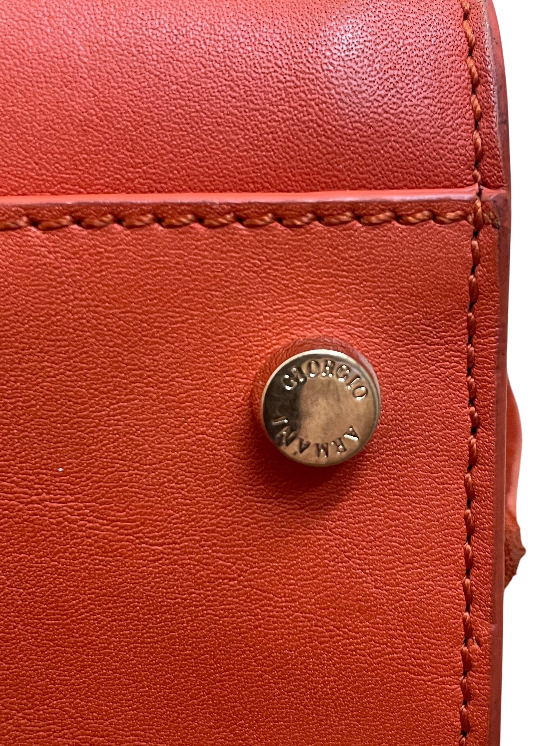 Vite con logo Giorgio Armani sul fondo della borsa arancio