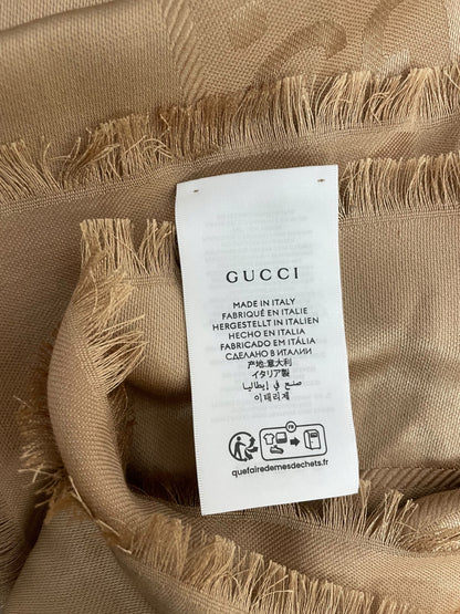Etichetta Gucci Made in Italy su scialle cammello