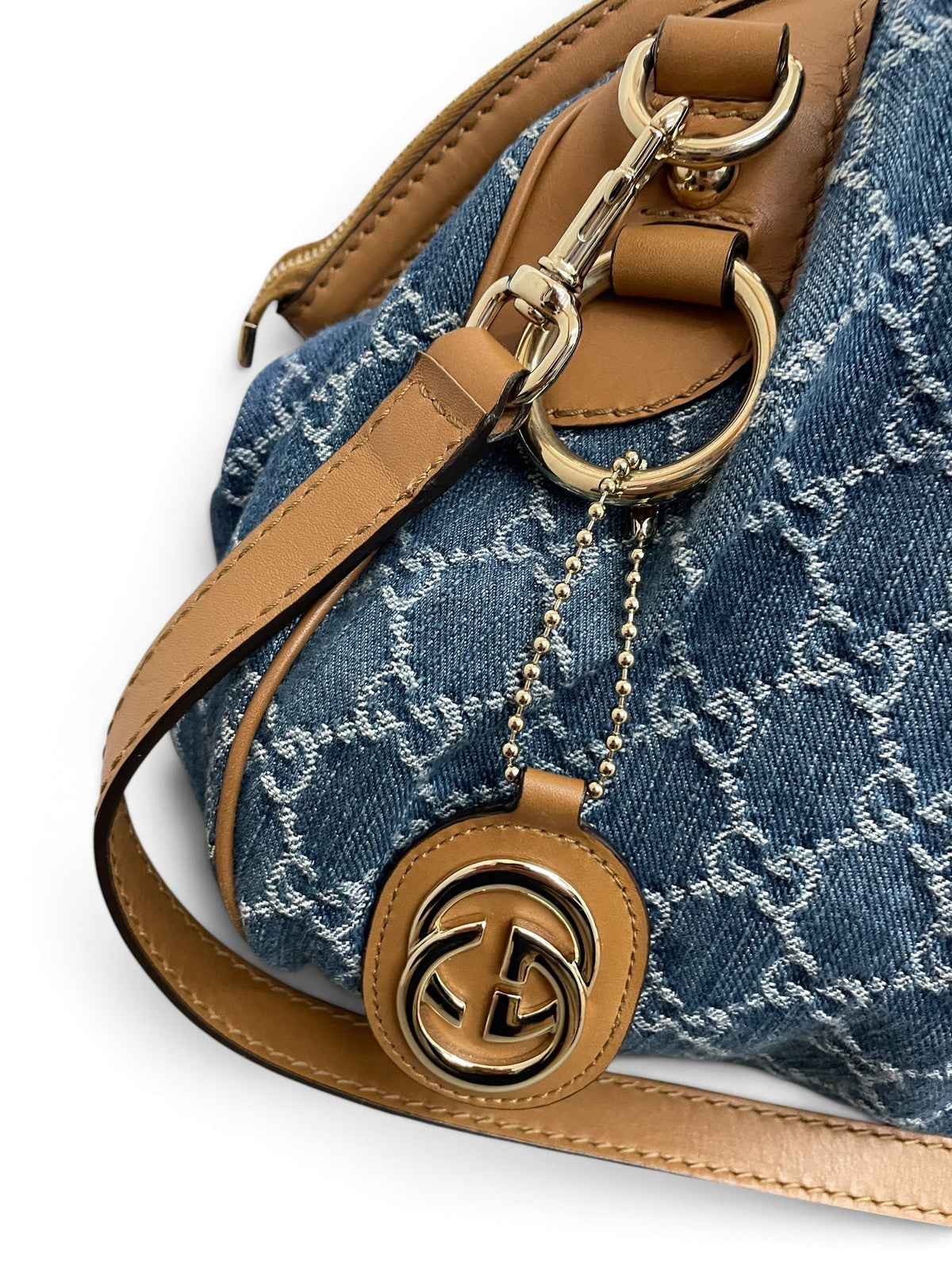 Dettaglio ciondolo GG Interlocking dorato Gucci Sukey Bag denim