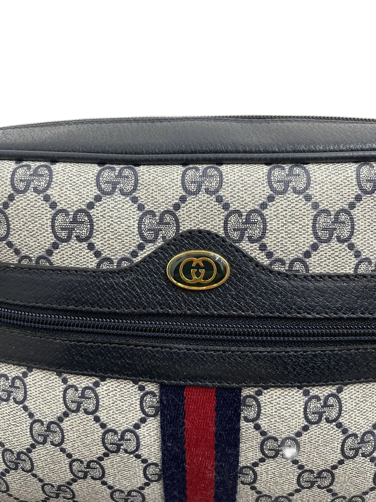 Dettaglio del logo GG dorato e della banda Web blu e rossa su borsa Gucci vintage