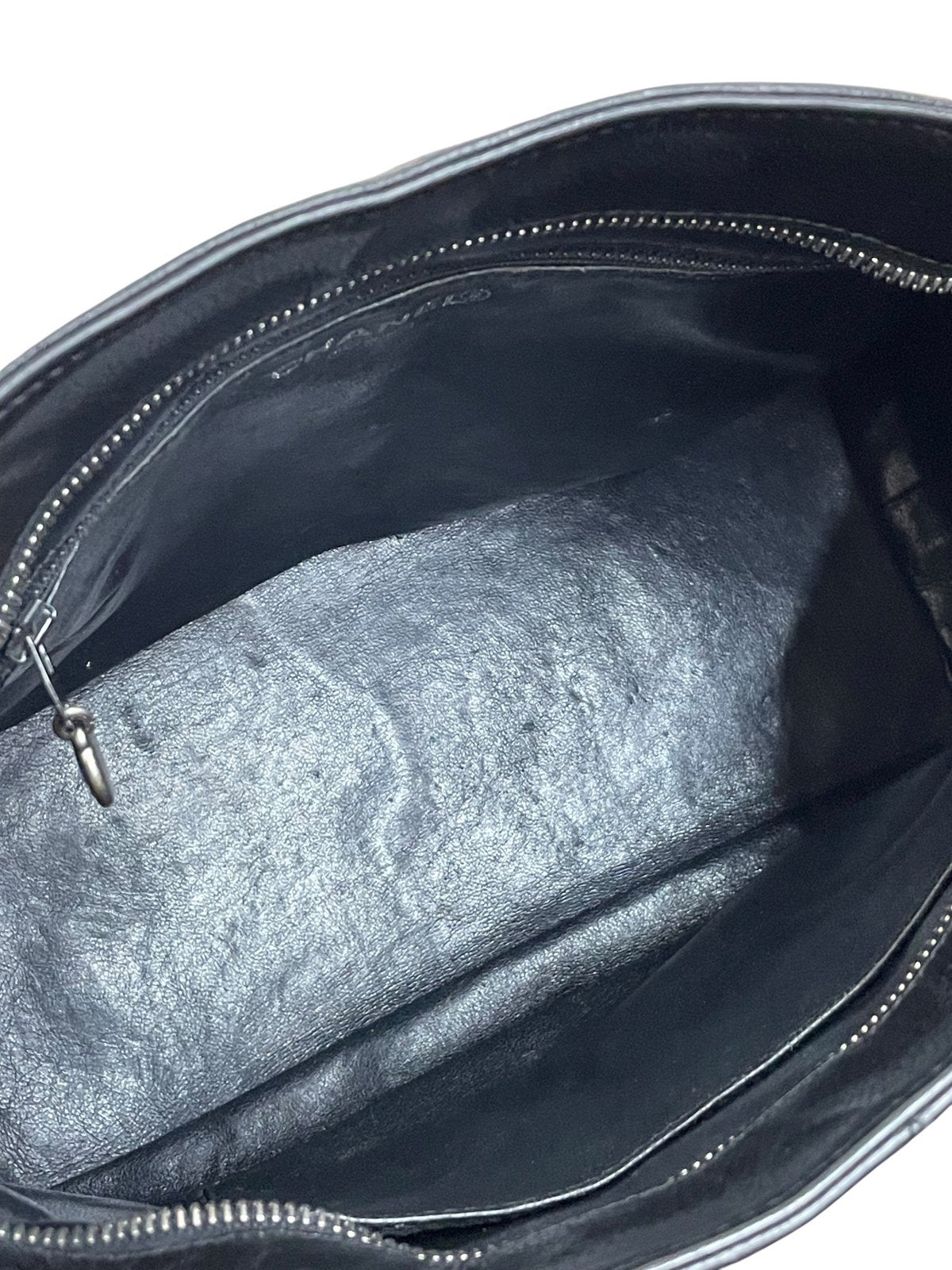 Vista aerea dello scomparto interno della borsa Chanel Medallion foderato in pelle nera con tasche