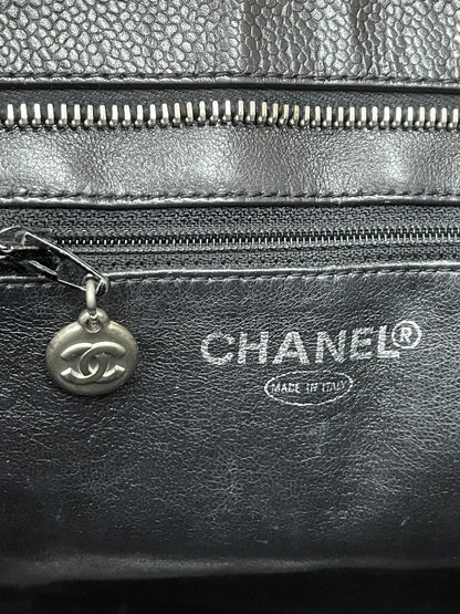 Dettaglio del logo Chanel stampato in lettere argentate all'interno e del piccolo medaglione tiralampo della tasca interna