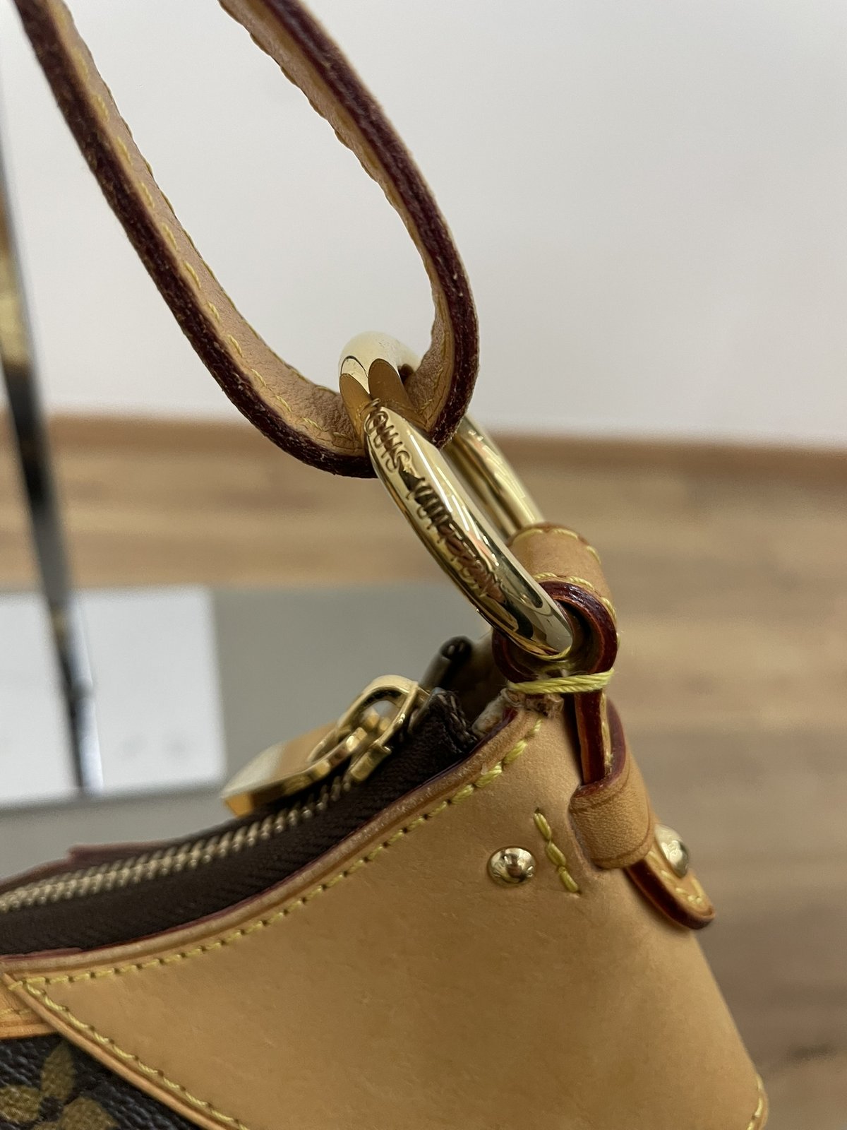 Dettaglio delle finiture in vacchetta e dell'anello dorato Louis Vuitton