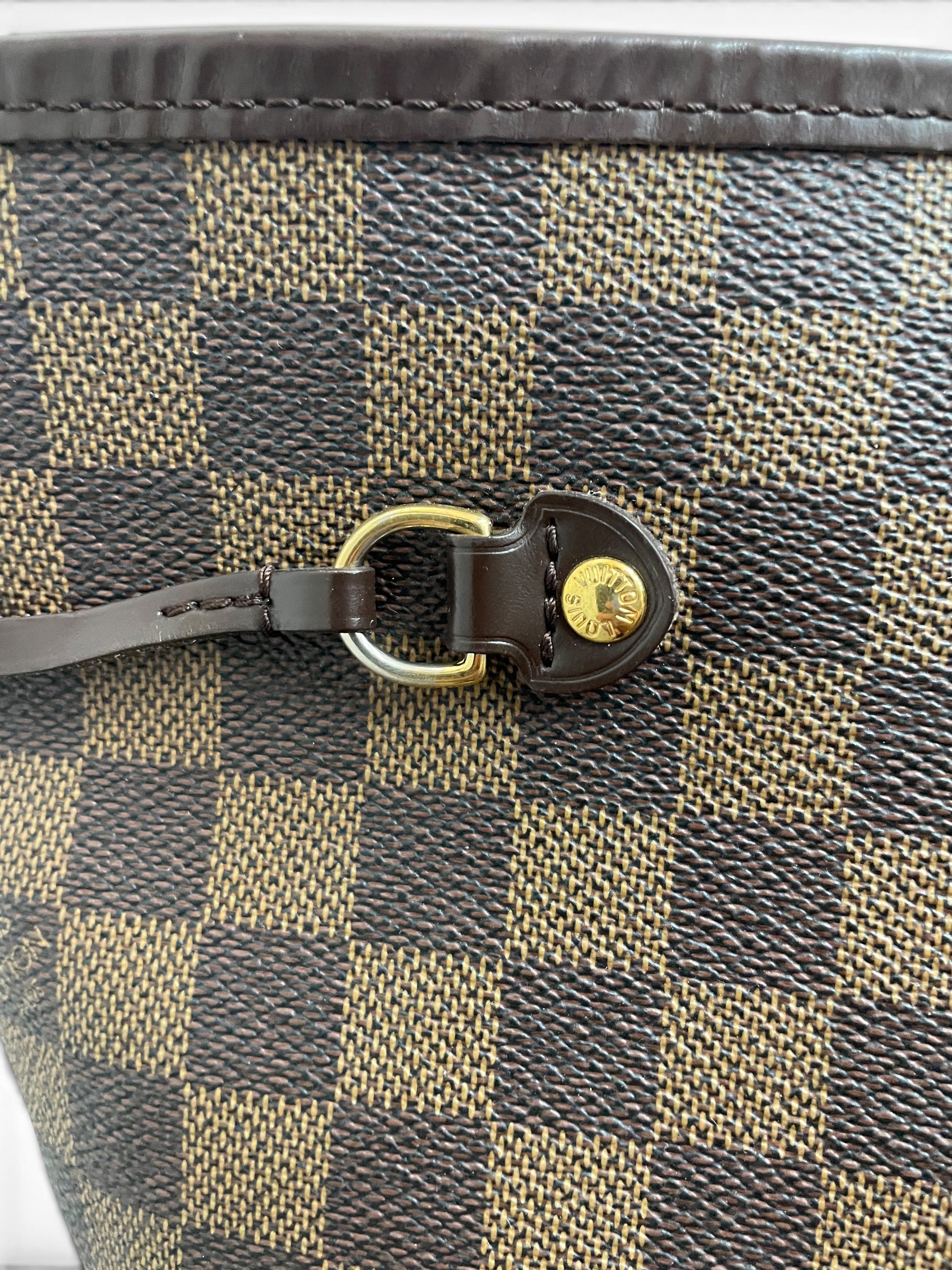 Dettaglio fibbia laterale dorata Louis Vuitton Neverfull GM