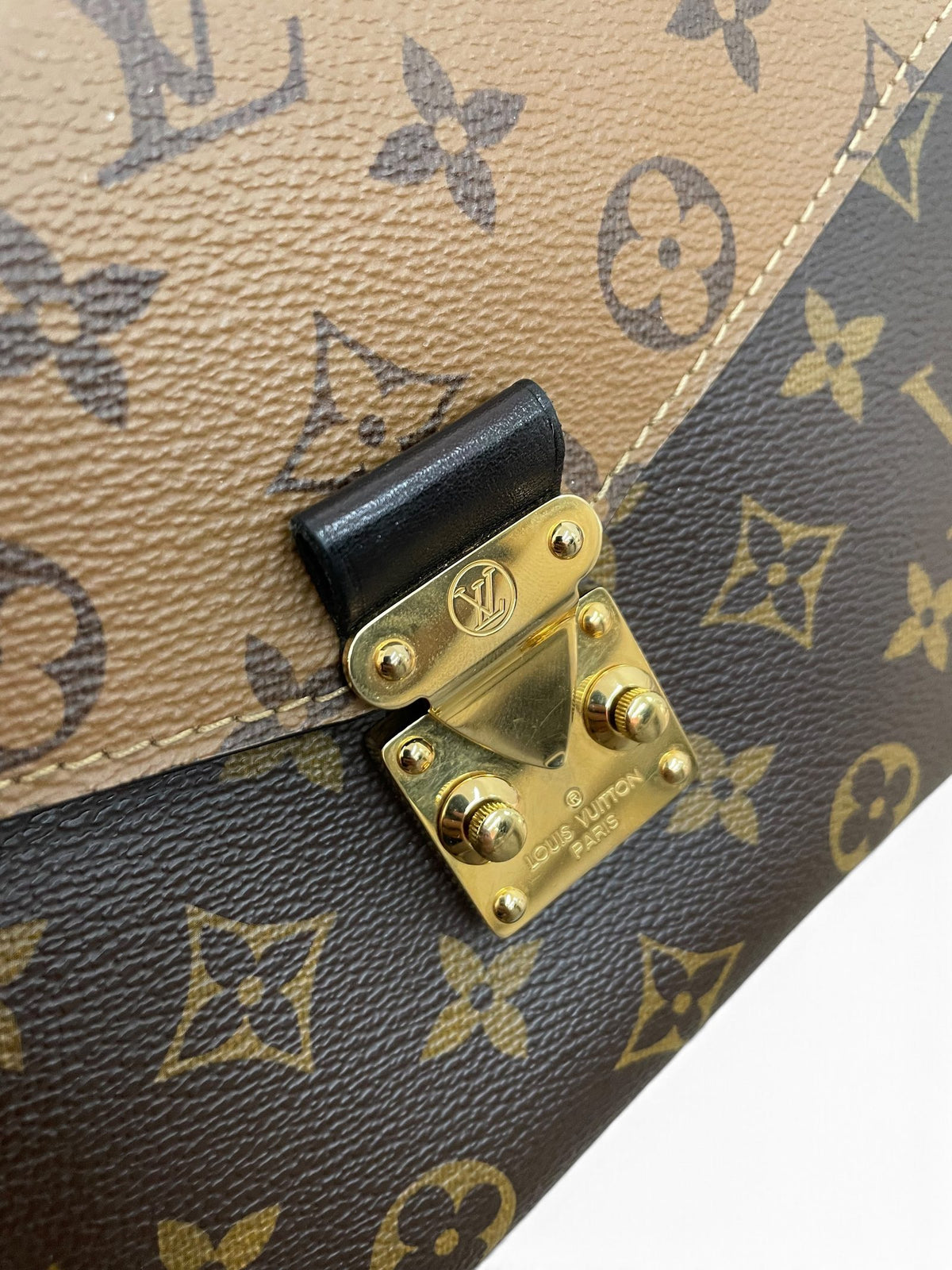 Dettaglio chiusura dorata a V Louis Vuitton Pochette Métis