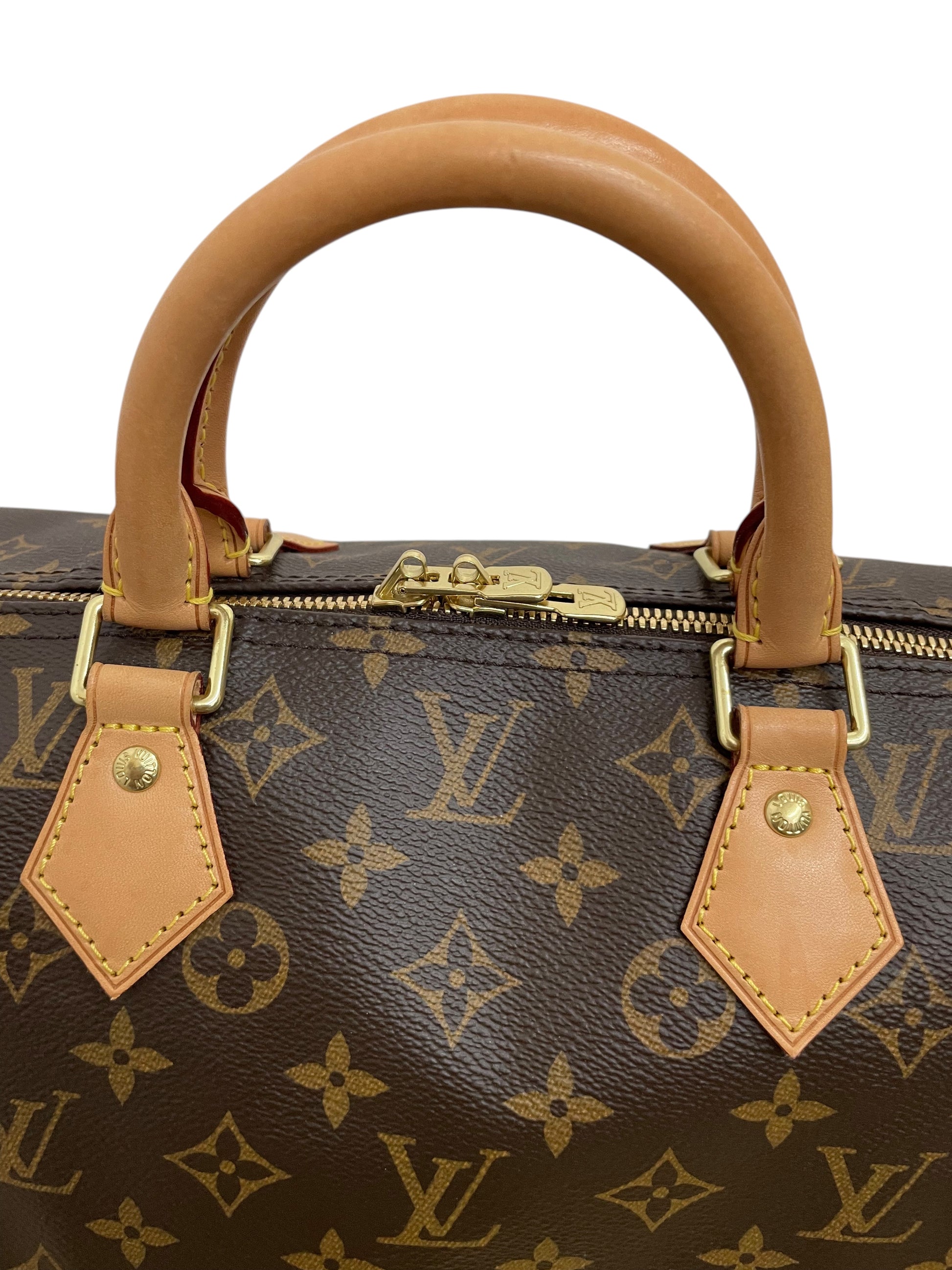 Dettaglio delle cuciture gialle e delle borchie dorate sull'attacco del manico Louis Vuitton.