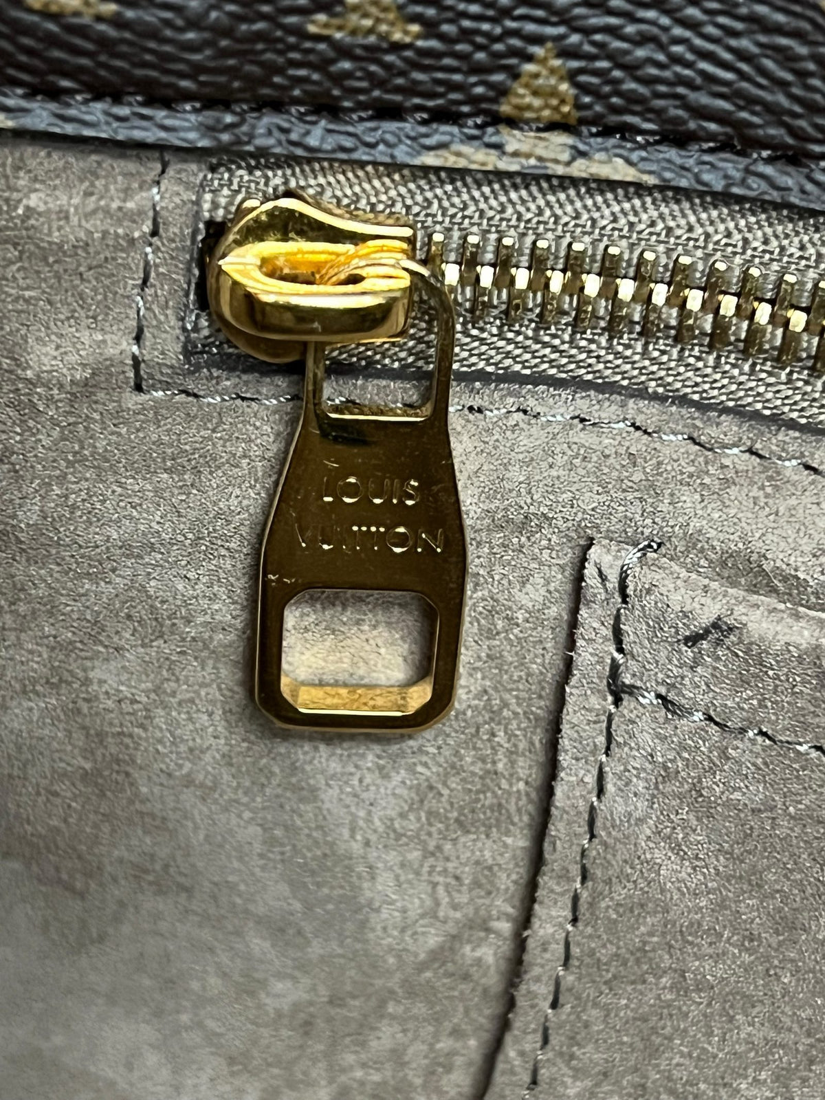 Dettaglio zip con logo Louis Vuitton dorato interno