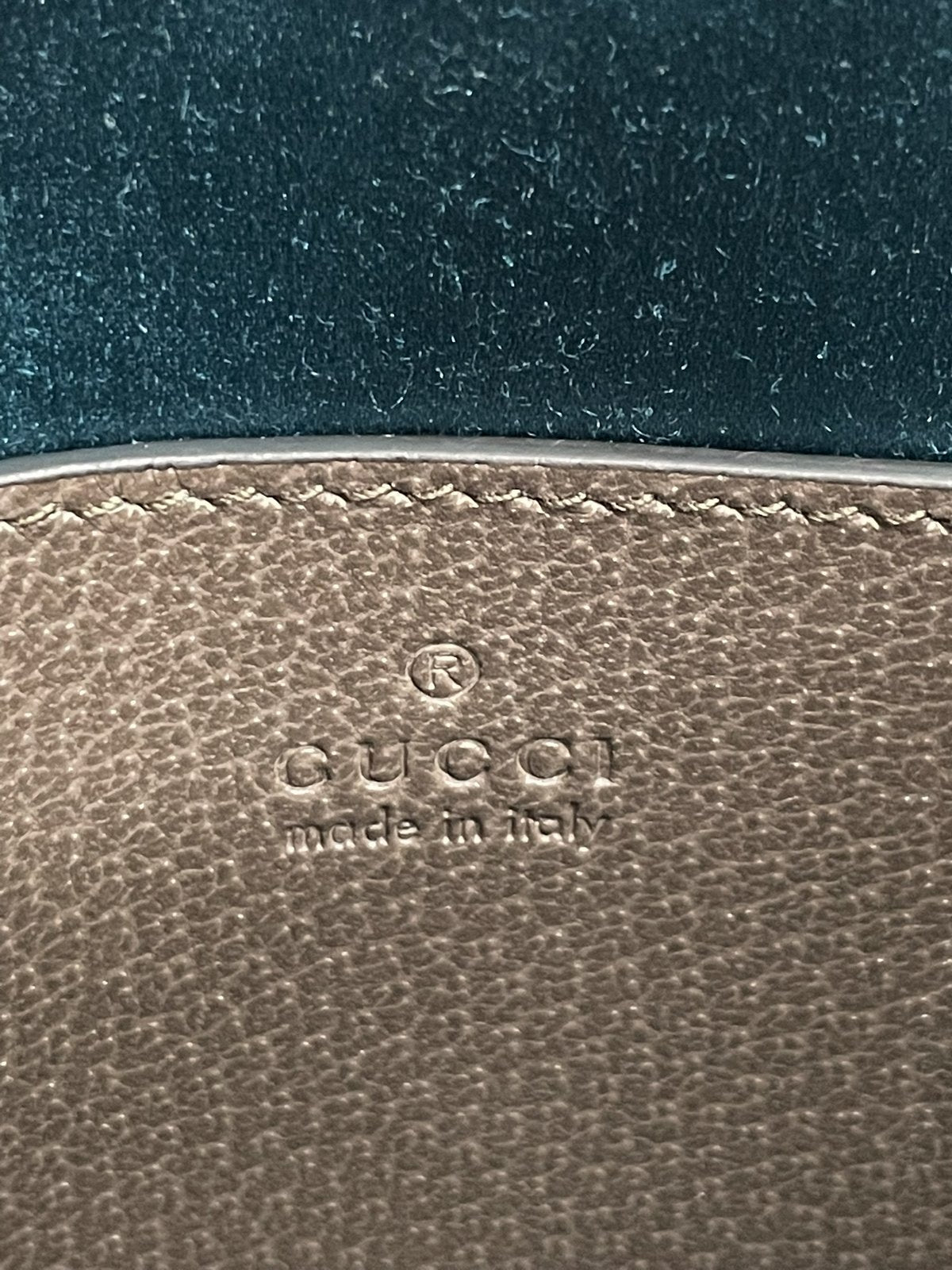 Dettaglio del marchio inciso a caldo sull'etichetta in pelle interna con logo Gucci e scritta made in italy