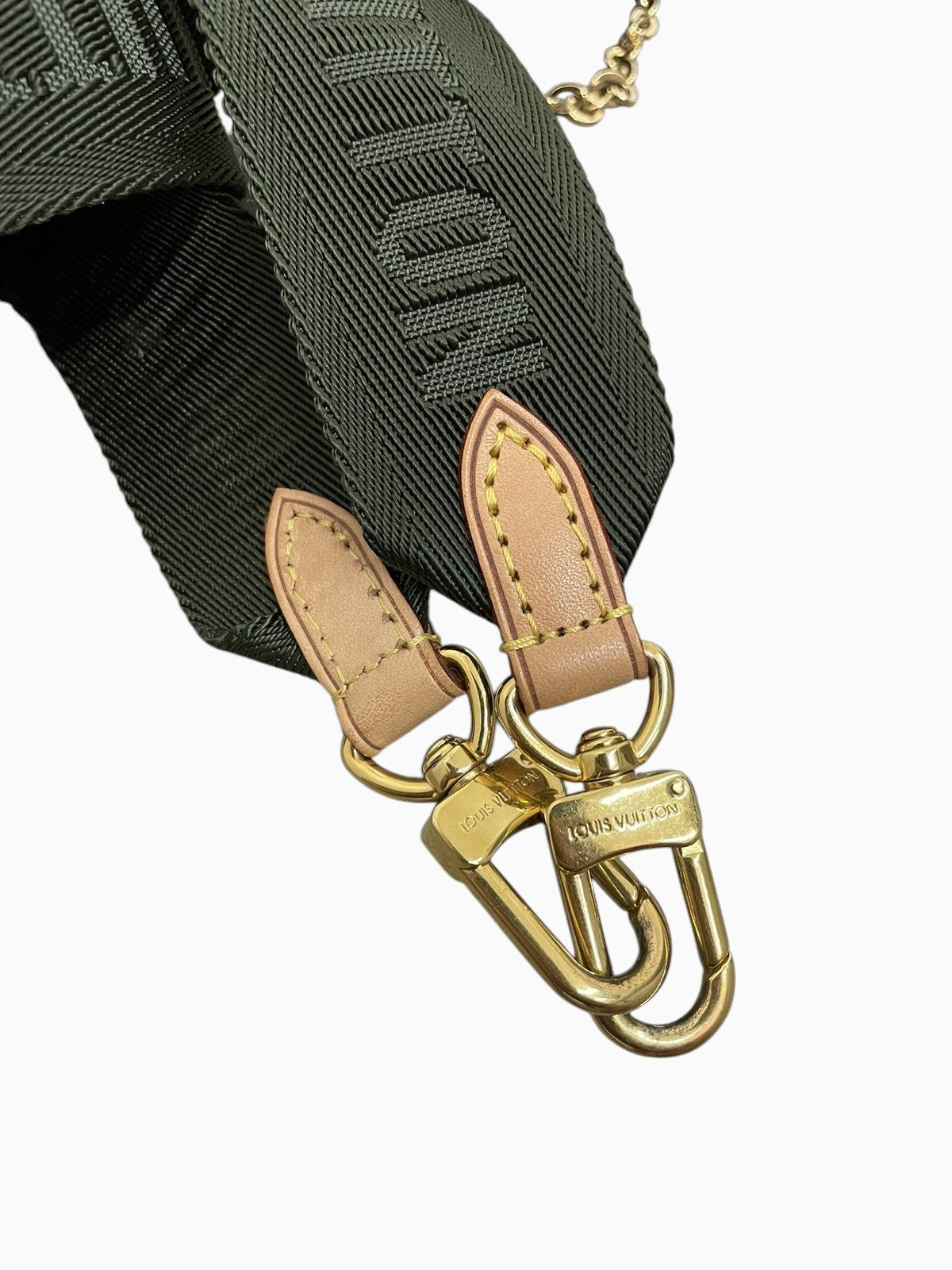 Dettaglio della tracolla in tessuto verde kaki con scritta Louis Vuitton ricamata